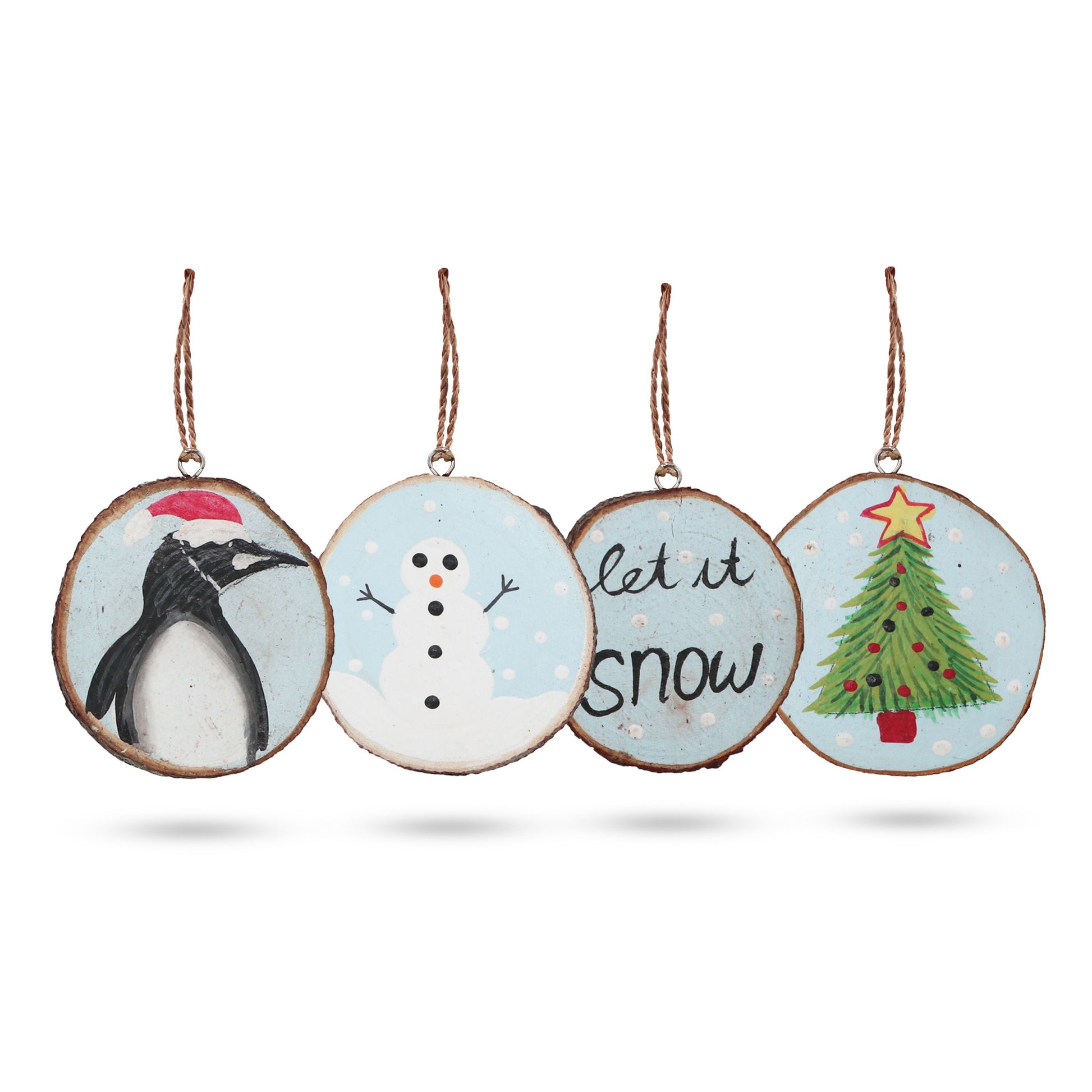 Set of four rustic hand-painted wooden log slices featuring festive Let it Snow winter designs for Christmas decorating.