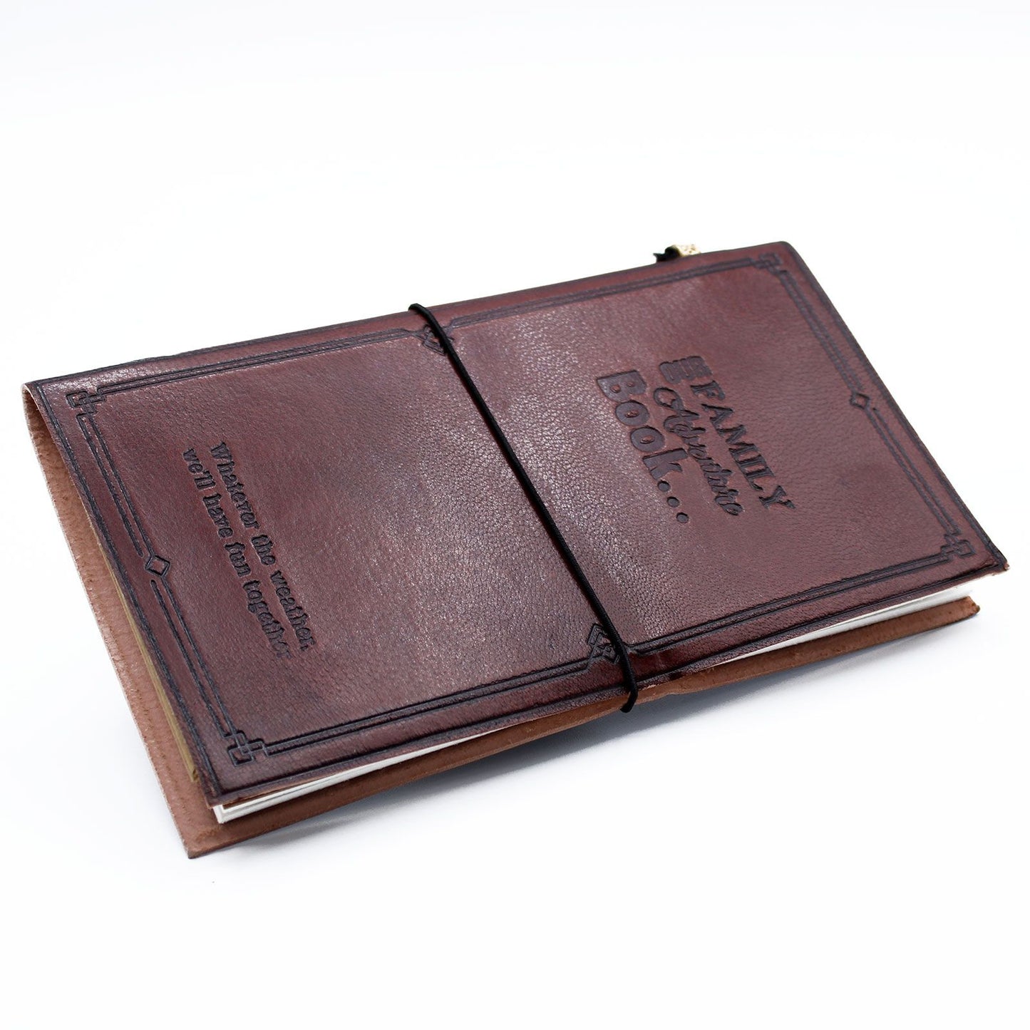 Slim brown leather journal with embossed 'Our Family Adventure Book' text and a leather wrap-around closure band.