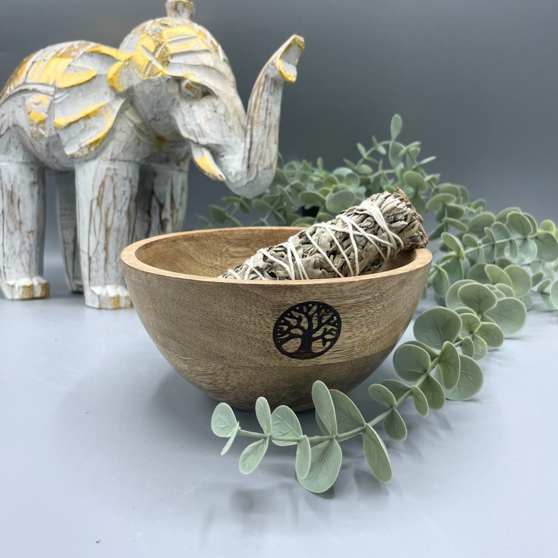 Handcrafted wooden ritual bowl featuring an intricate Tree of Life carving on a natural grain surface.