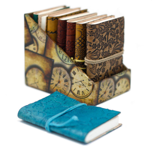 Small rustic brown leather notebook with metal clasp and wrap-around thong detail in a vintage journal style.