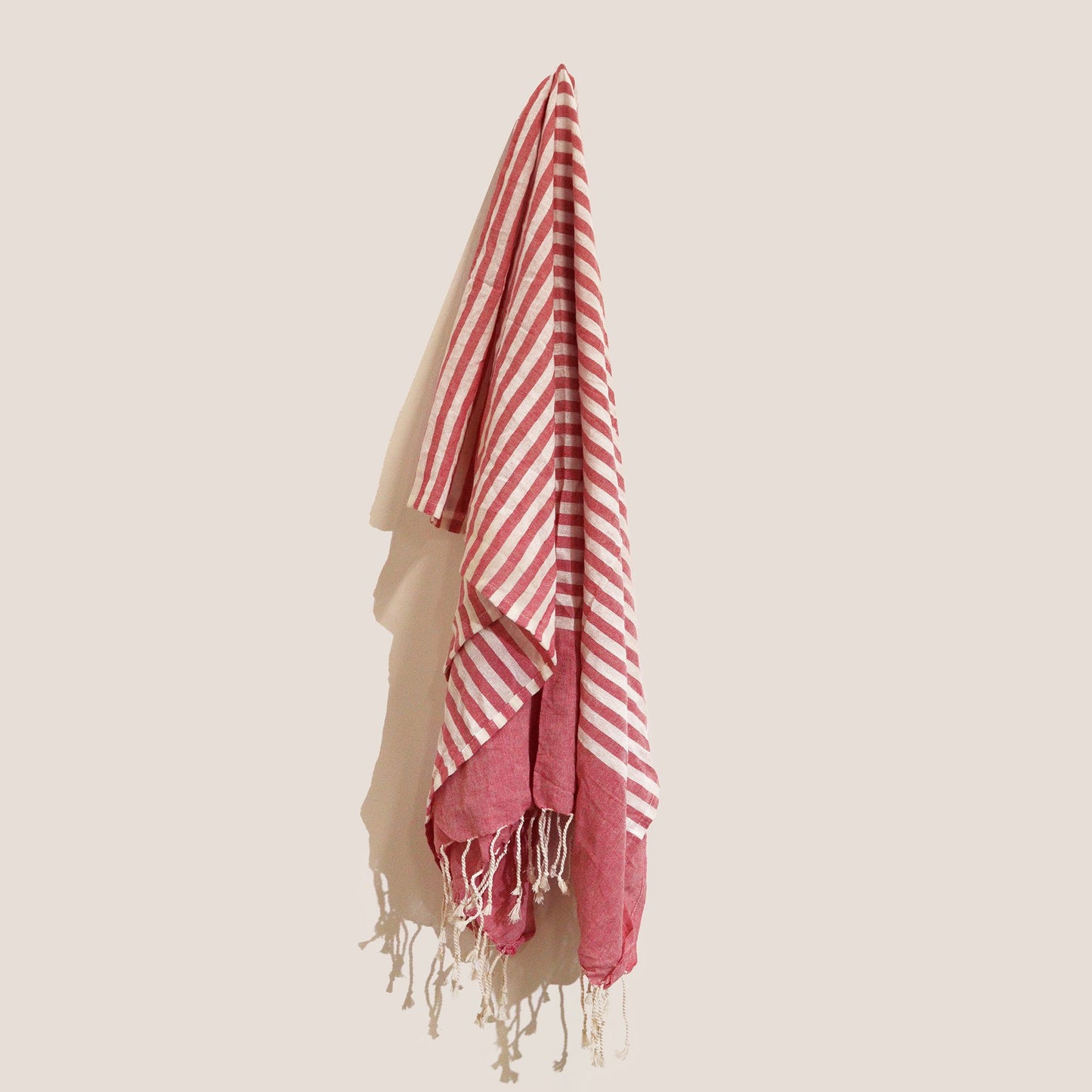 Vibrant hot pink handcrafted cotton pareo throw with delicate fringed edges and a soft woven texture.