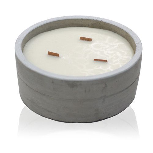 Large round concrete candle jar with a natural raw texture and a wooden wick, featuring a smooth wax surface.
