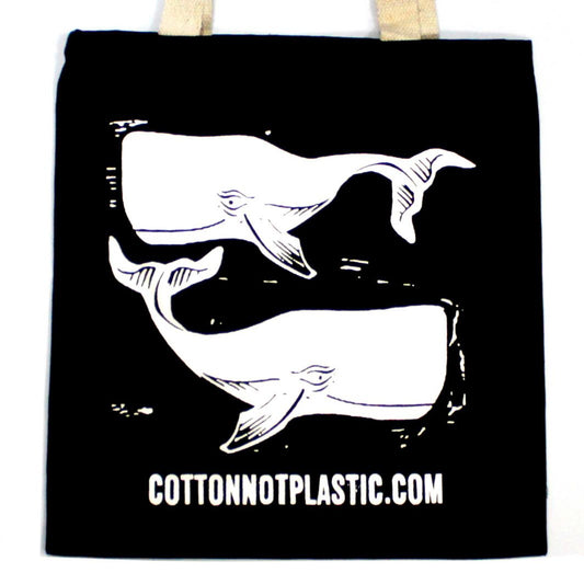 Large black cotton tote bag with white whale illustrations, featuring dual sets of handles on a neutral background.