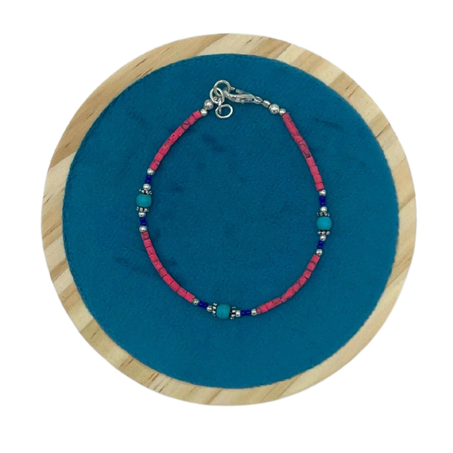 Handcrafted Nepalese bracelet featuring vibrant pink coral and cool turquoise gemstone beads in a striking contrast.