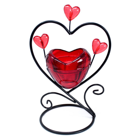 Elegant white ceramic candle holder featuring a small heart silhouette nested within a larger heart cutout.