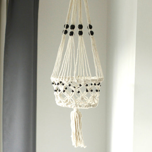 Large cream cotton macrame plant hanger featuring decorative wooden beads and intricate knotted patterns.