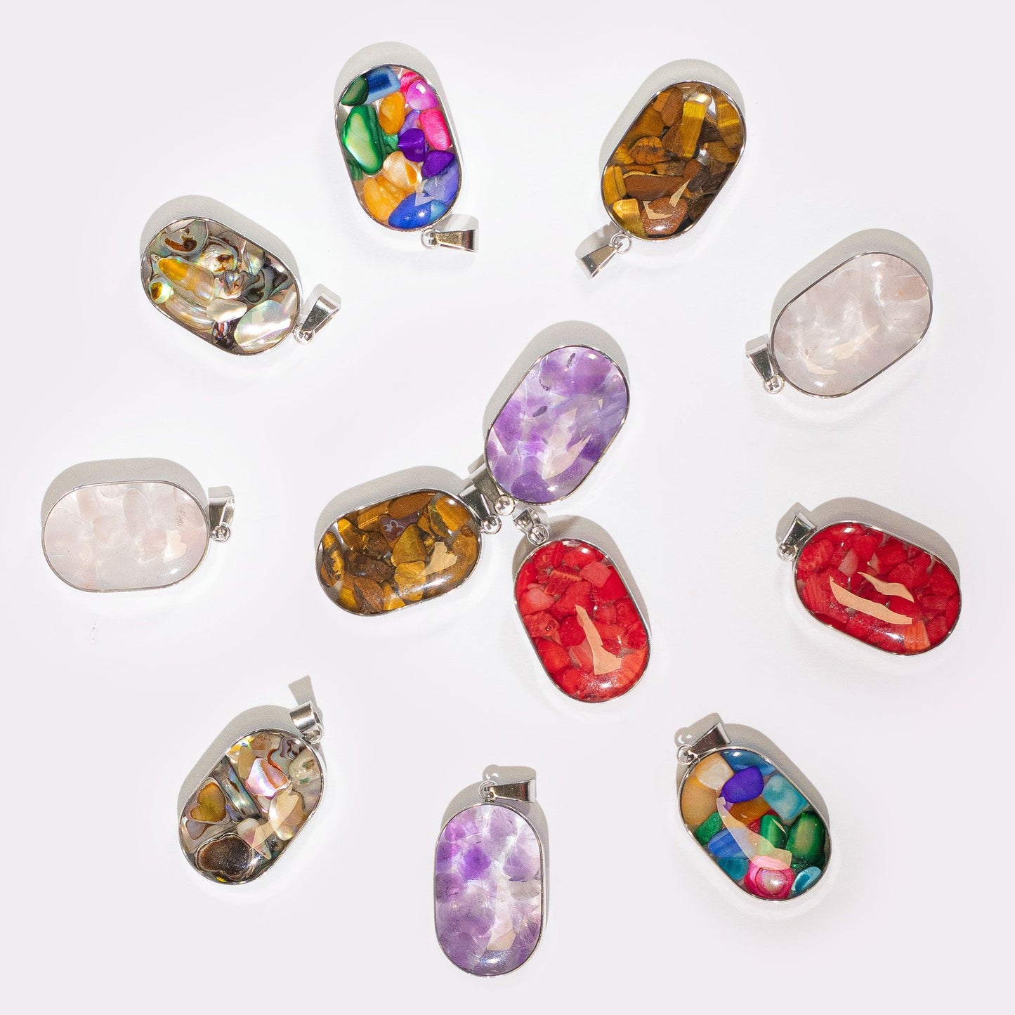Assorted oval steel-cased pendants filled with various colourful gemstone chips and natural shells.