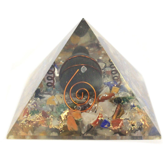Clear resin orgonite pyramid containing colourful gemstone chips, a copper coil, and a decorative metal turtle.