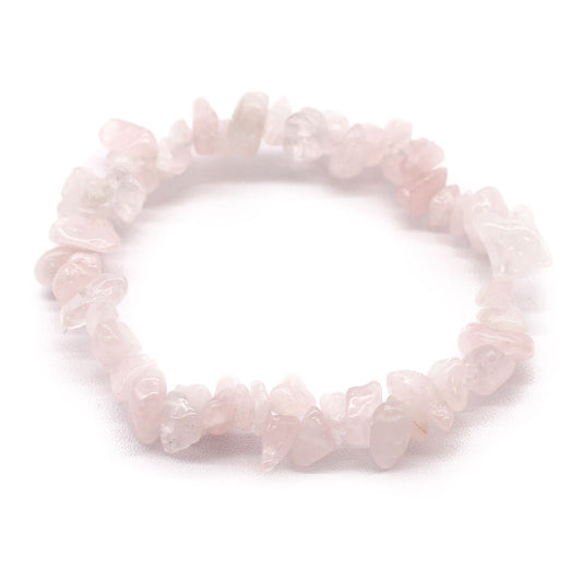 Close-up of a delicate rose quartz chipstone bracelet featuring polished pink gemstone shards on a clear elastic cord.