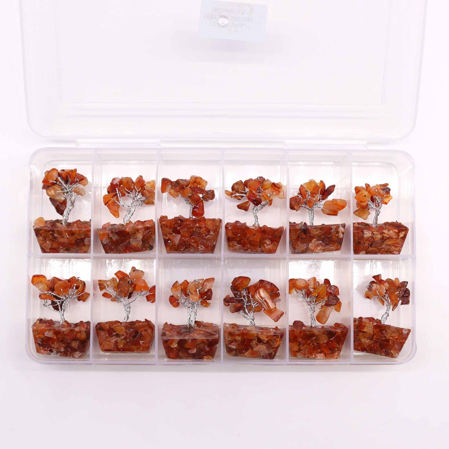 Small handcrafted gemstone tree with orange carnelian leaves on a decorative orgonite base.