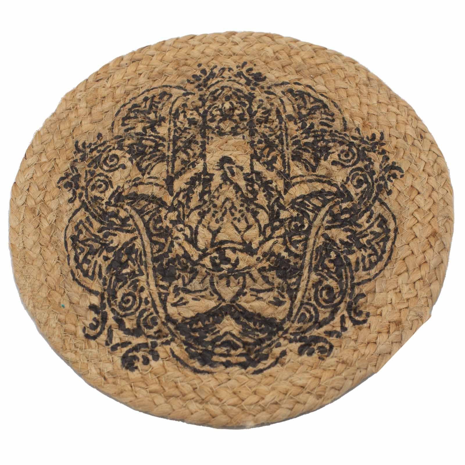 Round natural jute place mat with a black Hamsa hand print design on a rustic wooden surface.