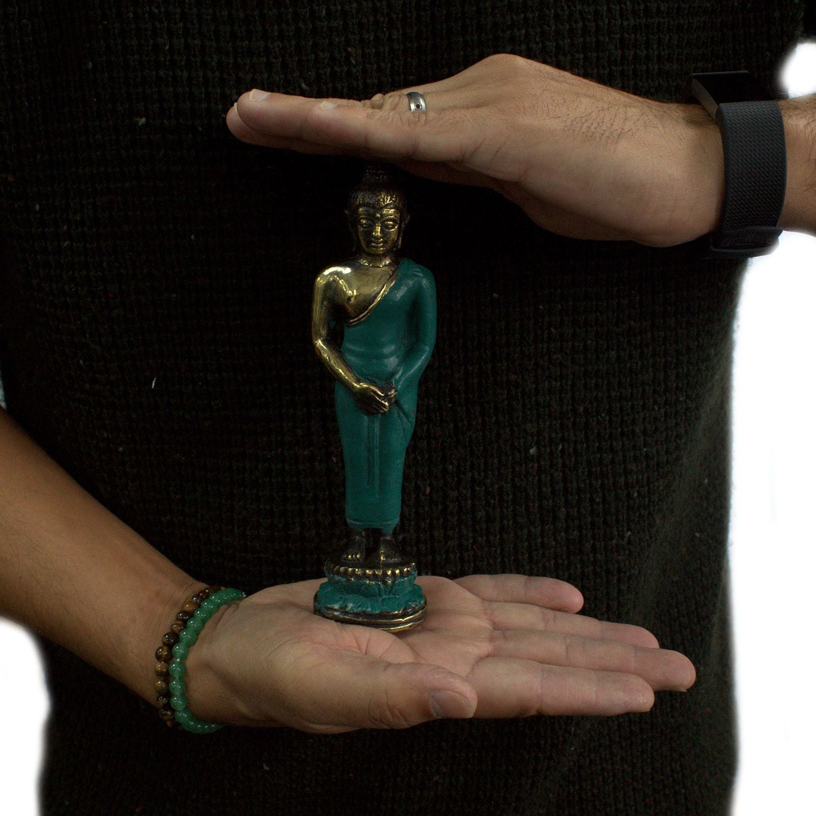 Detailed brass statue of a standing Buddha in a traditional pose on a tiered base.