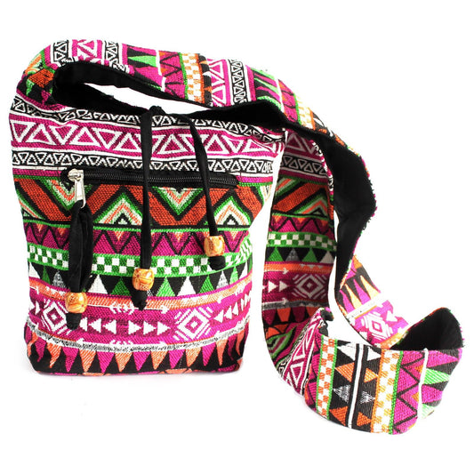 Pink ethnic jacquard fabric sling bag with a casual cross-body strap and intricate woven patterns.