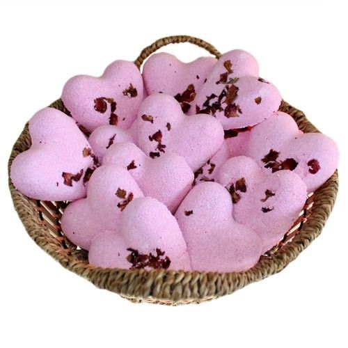 Heart-shaped pink bath fizzers with a delicate rose fragrance, perfect for a relaxing floral bath.