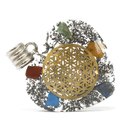 Heart shaped Orgonite pendant featuring layered chakra gemstones, copper spirals, and metal shavings in clear resin.