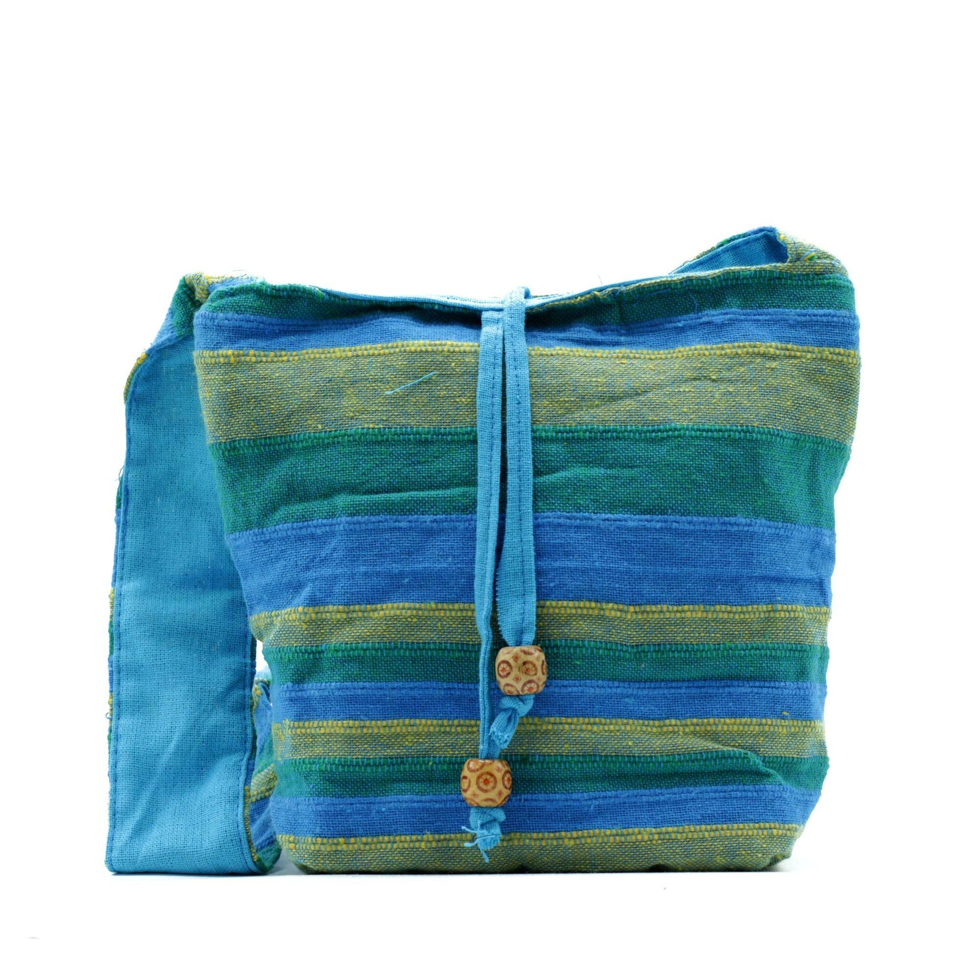 Colourful cotton sling bag with a floral spring meadows pattern in vibrant shades of green and blue.