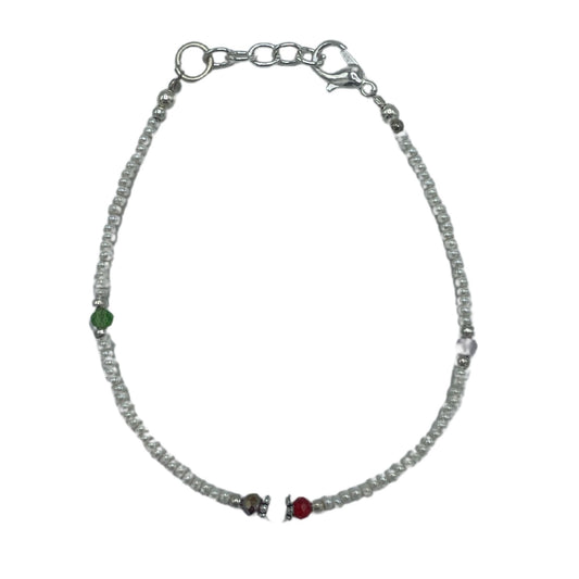 Handcrafted Nepalese bracelet featuring luminous white pearls and intricately faceted beads in a refined cultural design.