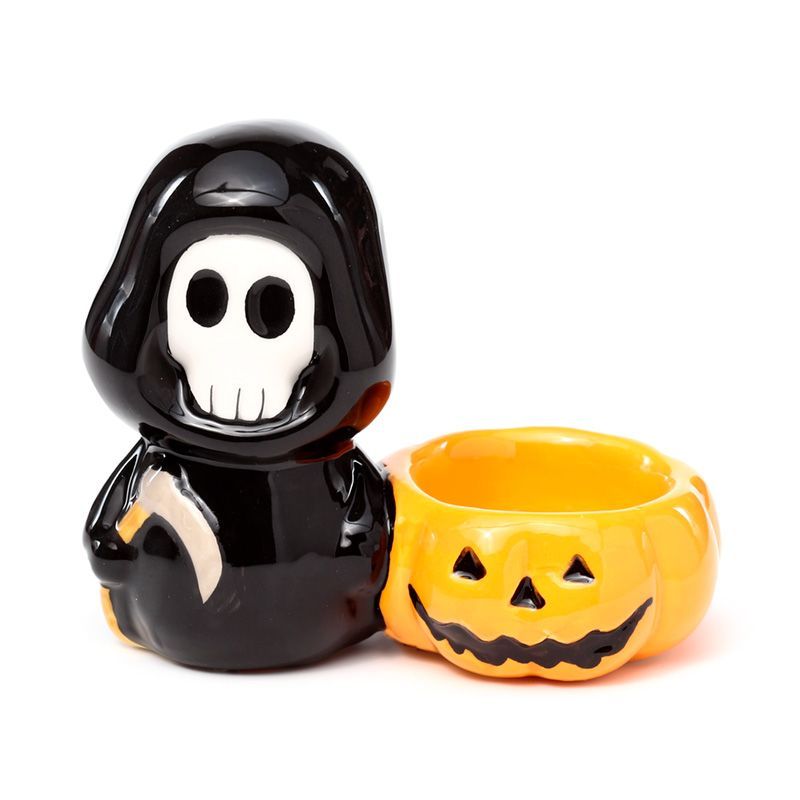 White ceramic skull tea light holder with a mischievous grin and detailed skeletal features.