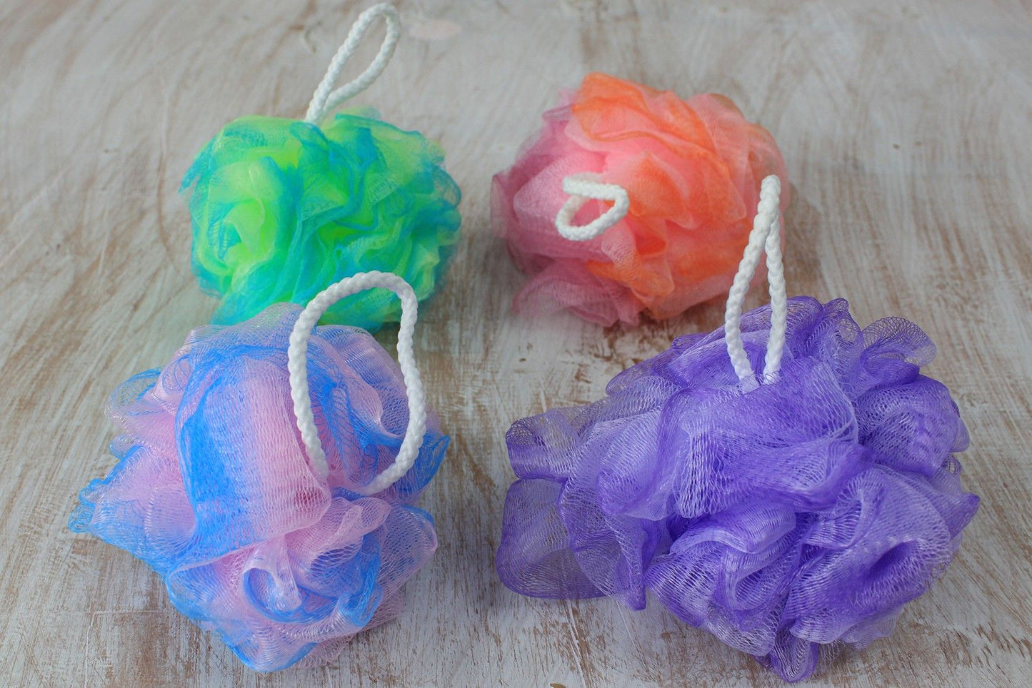 Soft variegated mesh bath scrunchie in assorted colours for gentle exfoliation and rich lather.