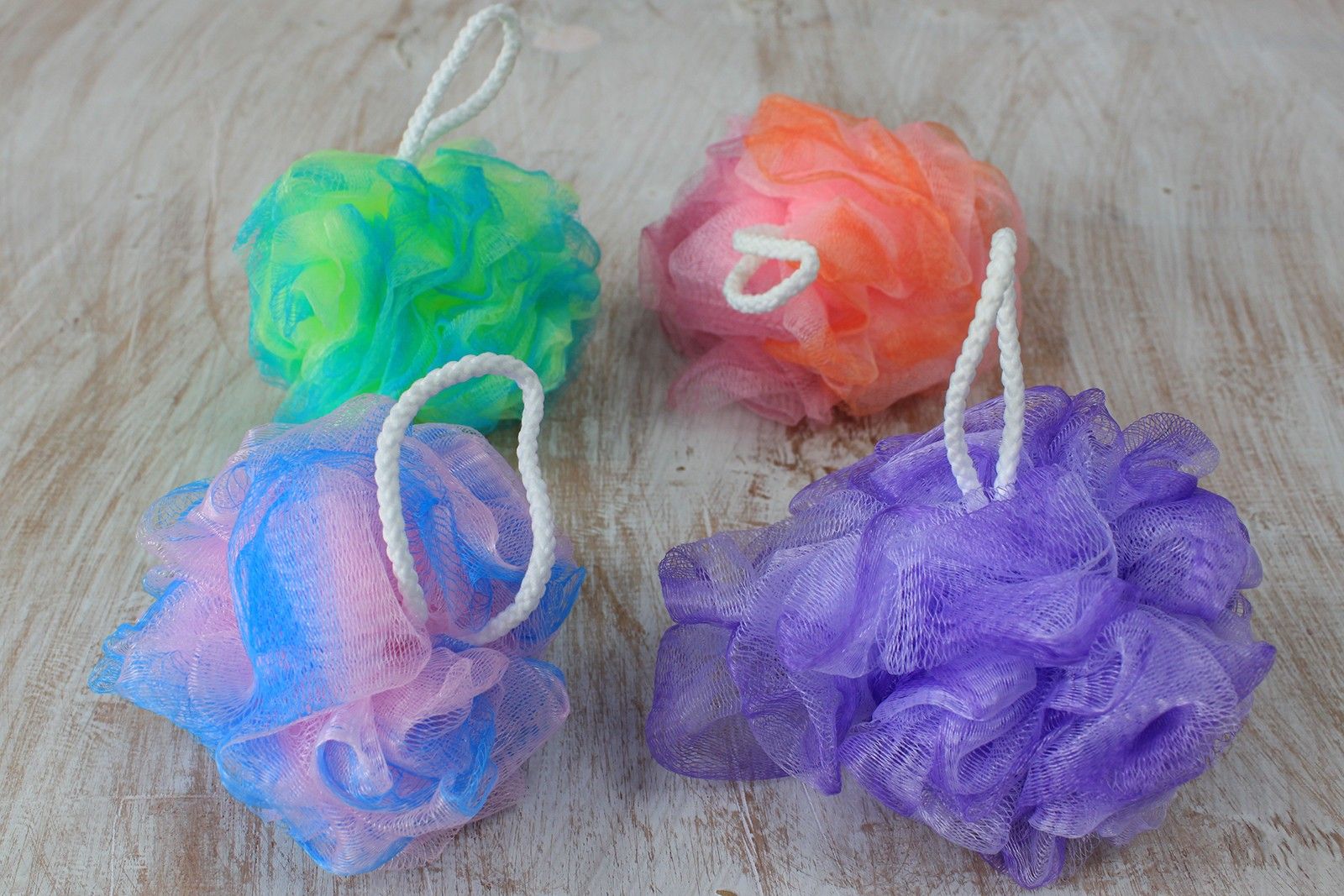 Soft variegated mesh bath scrunchie in assorted colours for gentle exfoliation and rich lather.