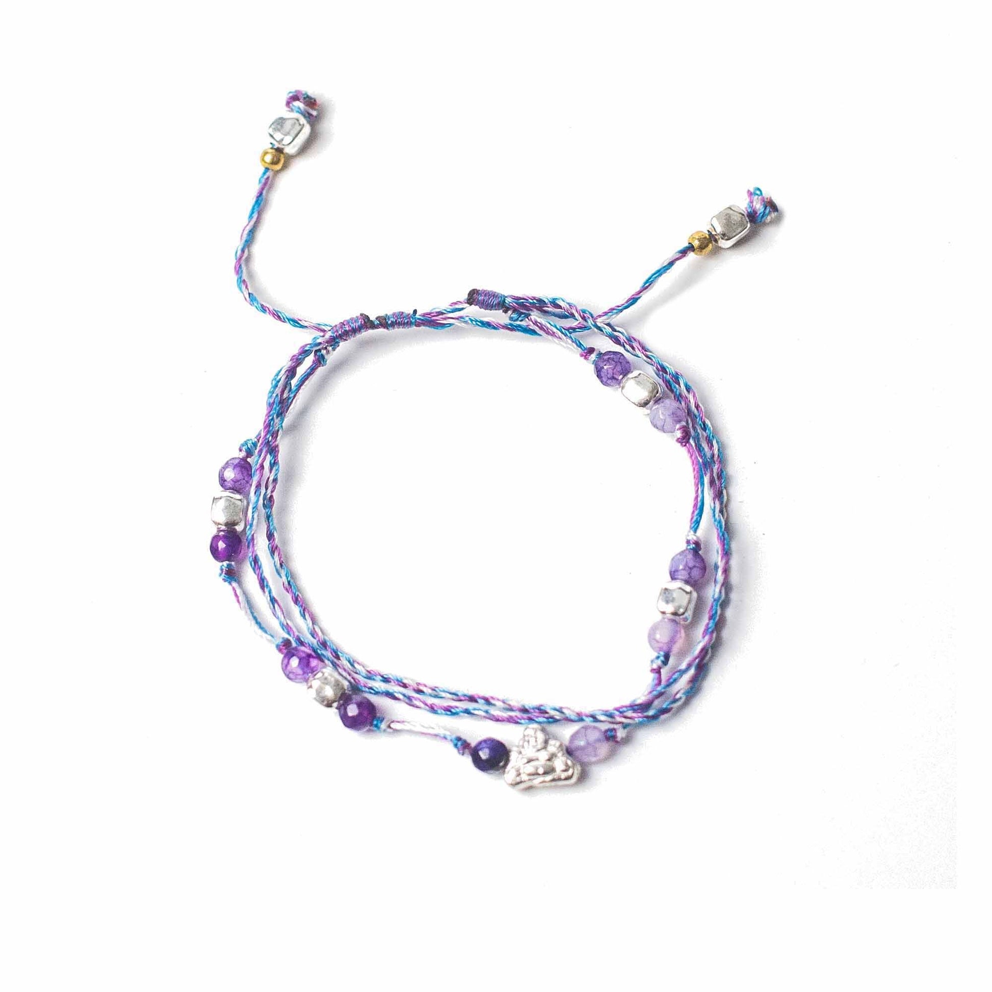 Close-up of a handcrafted colourful temple string bracelet featuring symbolic charms for protection and abundance.