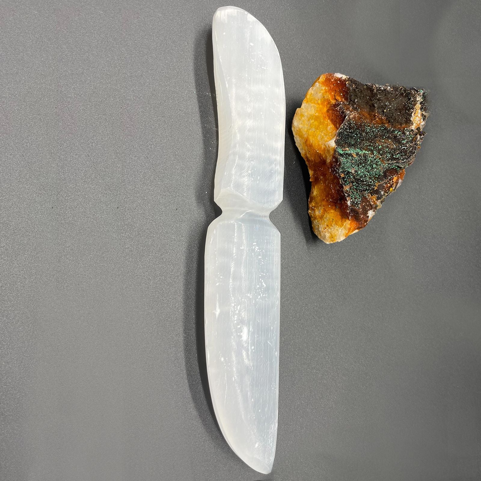 Hand-carved white selenite ceremonial knife with a pointed blade and decorative handle.