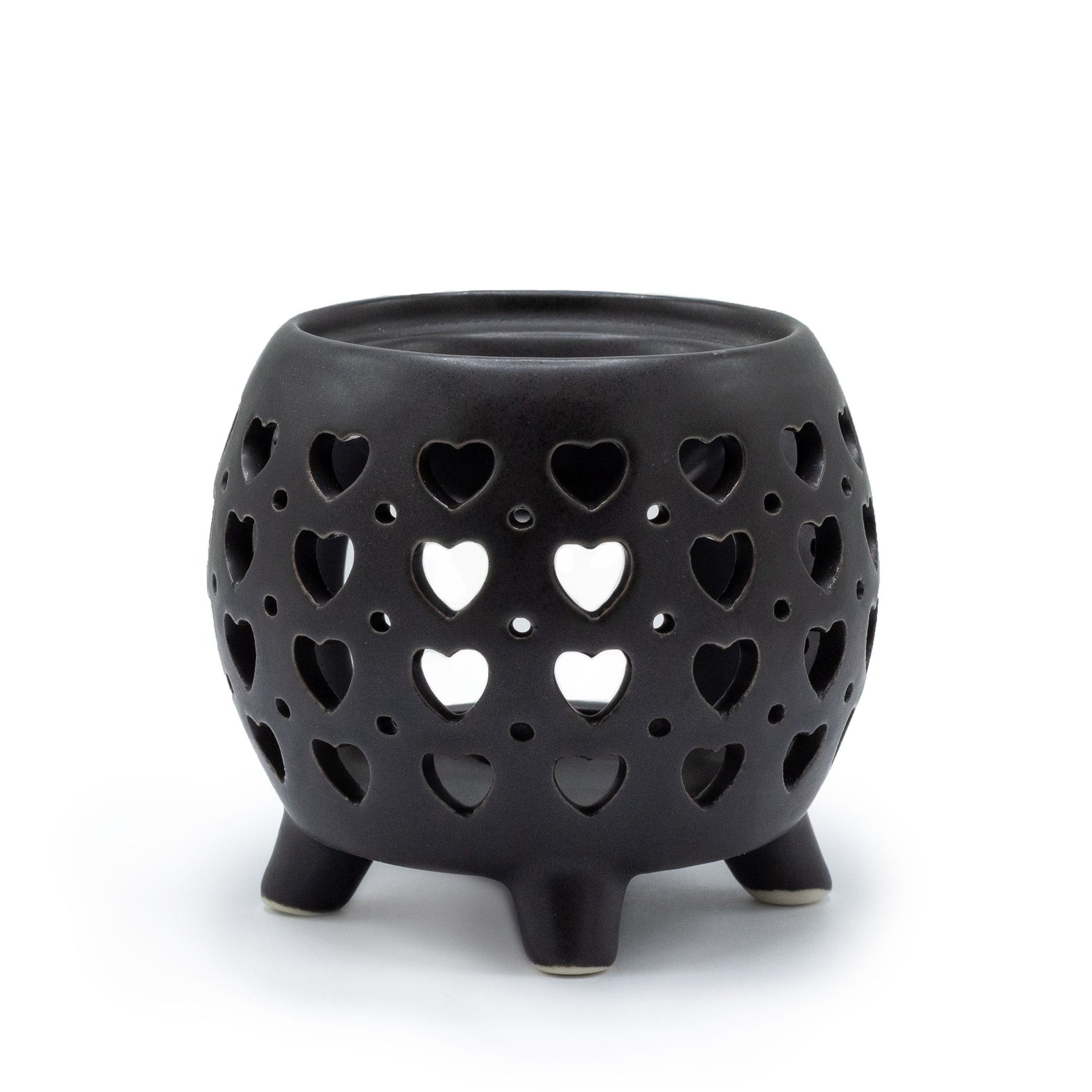 Contemporary squat pot ceramic oil burner in a matt black finish featuring a decorative multi heart cut-out design.