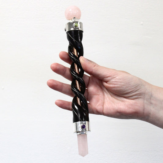 Elegant spiral carved rose quartz crystal wand encased in a polished copper pipe handle.