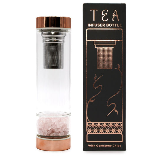 Elegant crystal glass tea infuser bottle with rose gold caps and soft pink rose quartz gemstones in the base.