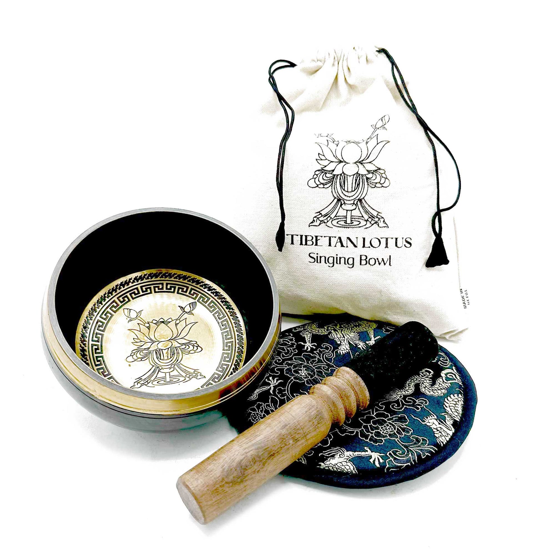 Hand-beaten 14cm metal singing bowl with an intricate engraved lotus flower design, wooden mallet, and patterned cushion.