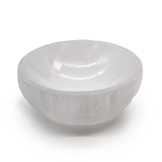A smooth, white translucent 10cm round bowl carved from natural selenite crystal with a pearly luster.