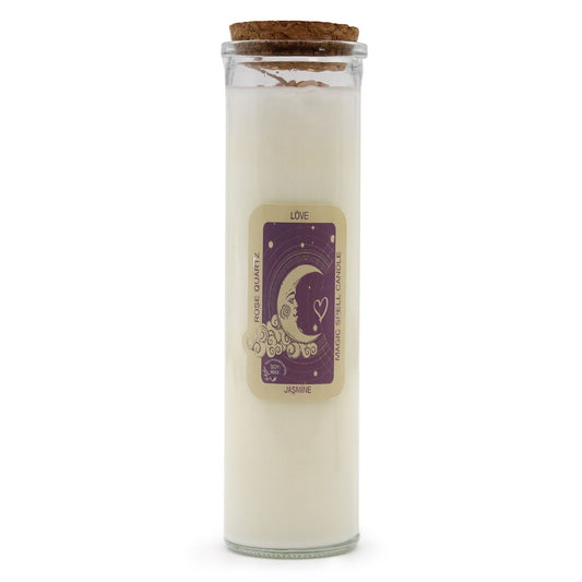 Pink soy wax candle in a glass jar topped with rose quartz gemstones and dried botanicals.