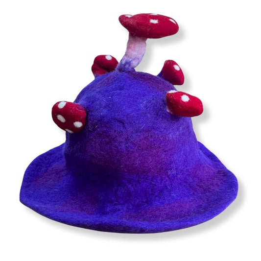 Handcrafted felted wool mushroom hat in a deep violet purple with white spots and a whimsical pointed shape.