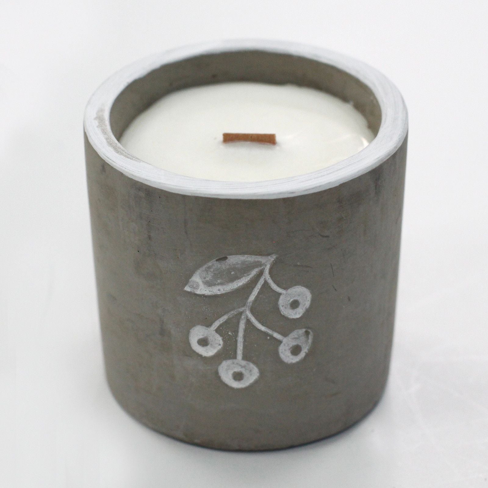 Handcrafted grey concrete candle pot with a natural wooden wick and smooth wax surface on a minimalist background.