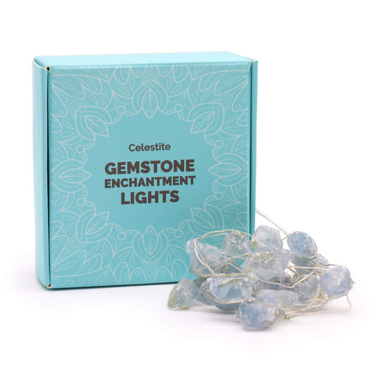 Sparkling blue celestite gemstone string lights glowing with a soft warm light against a dark background.