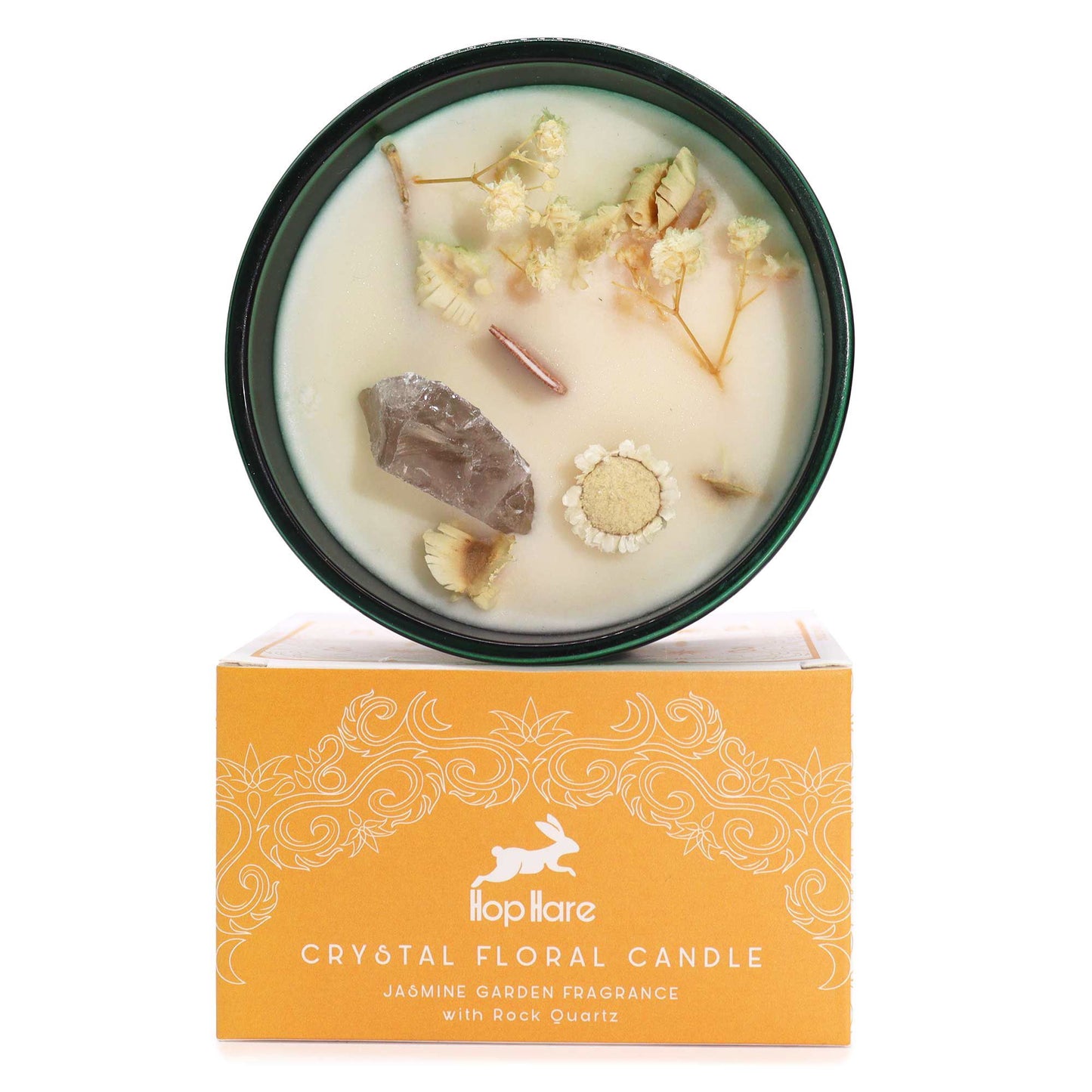 Soy wax candle in a glass jar topped with dried flowers and a raw rock quartz crystal point.