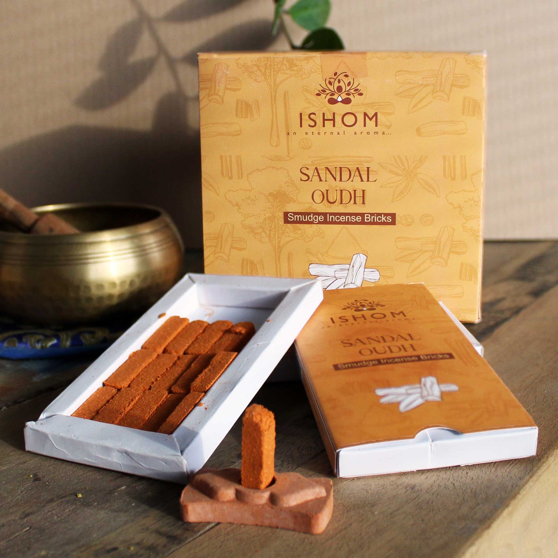 Pack of fifteen dark brown sandalwood incense bricks arranged next to a small round terracotta burner bowl.