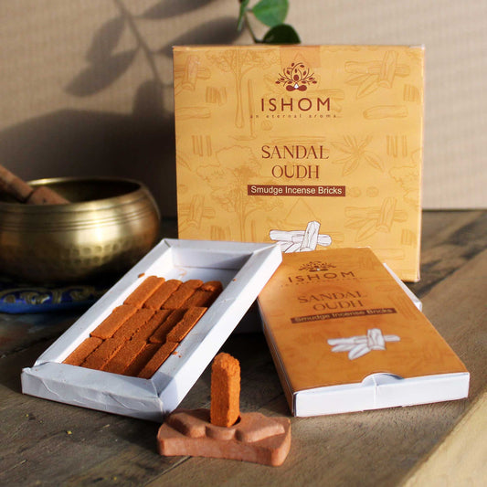 Pack of fifteen dark brown sandalwood incense bricks arranged next to a small round terracotta burner bowl.