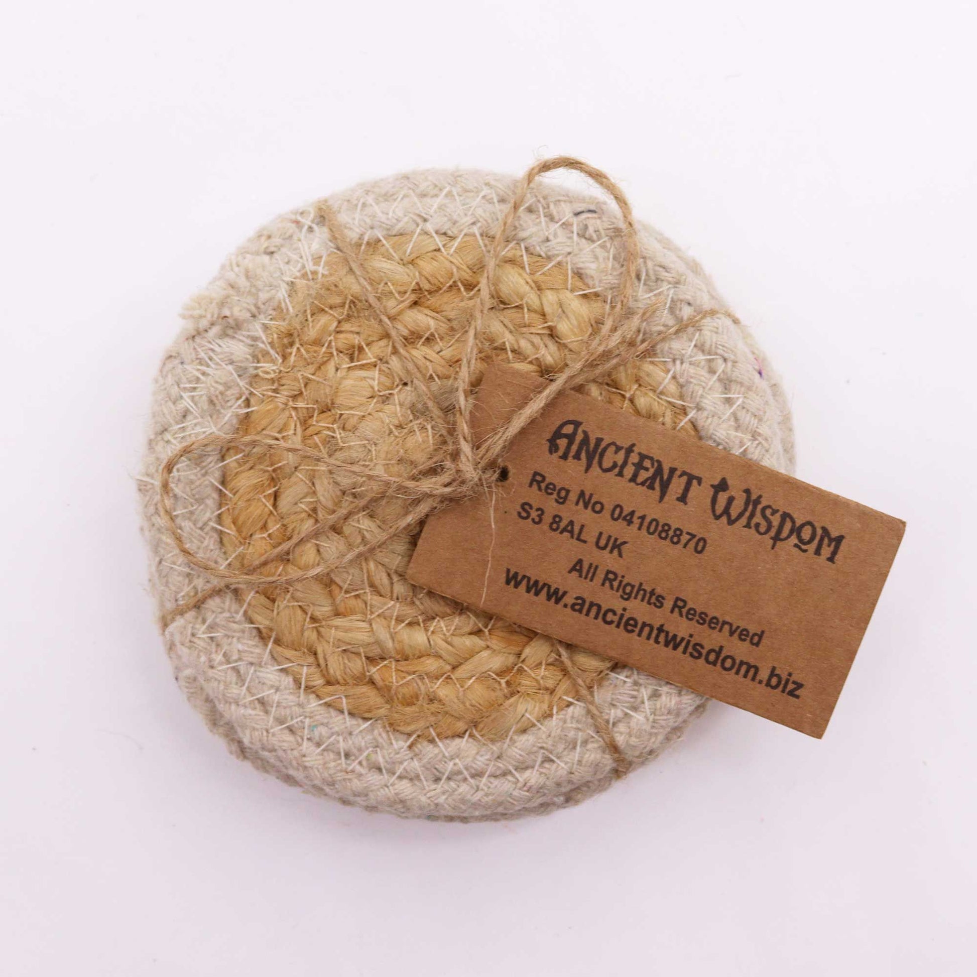 Set of four round natural jute and cotton coasters with a cream ivory stitched border on a wooden surface.