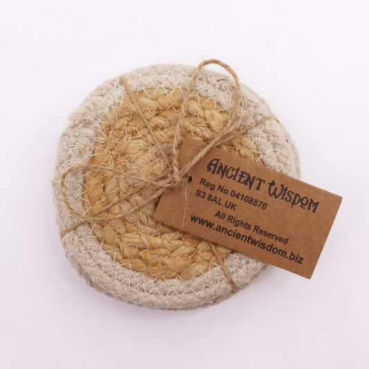 Set of four round natural jute and cotton coasters with a cream ivory stitched border on a wooden surface.