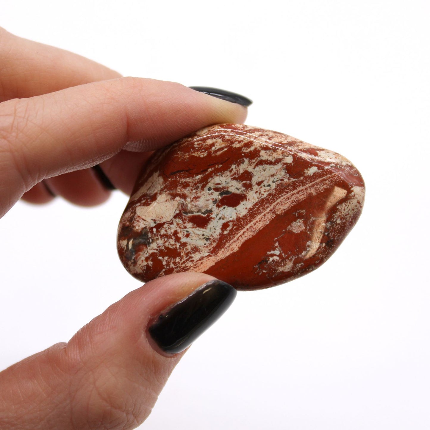 A smooth, polished large tumble stone of brecciated light jasper showing earthy red and cream patterns.