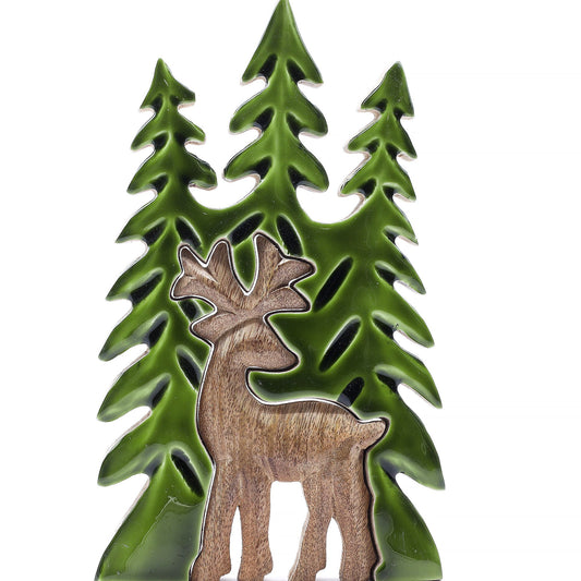 Hand-carved mango wood stag standing among three green enamel pine trees in a 3D layered wooden decoration.