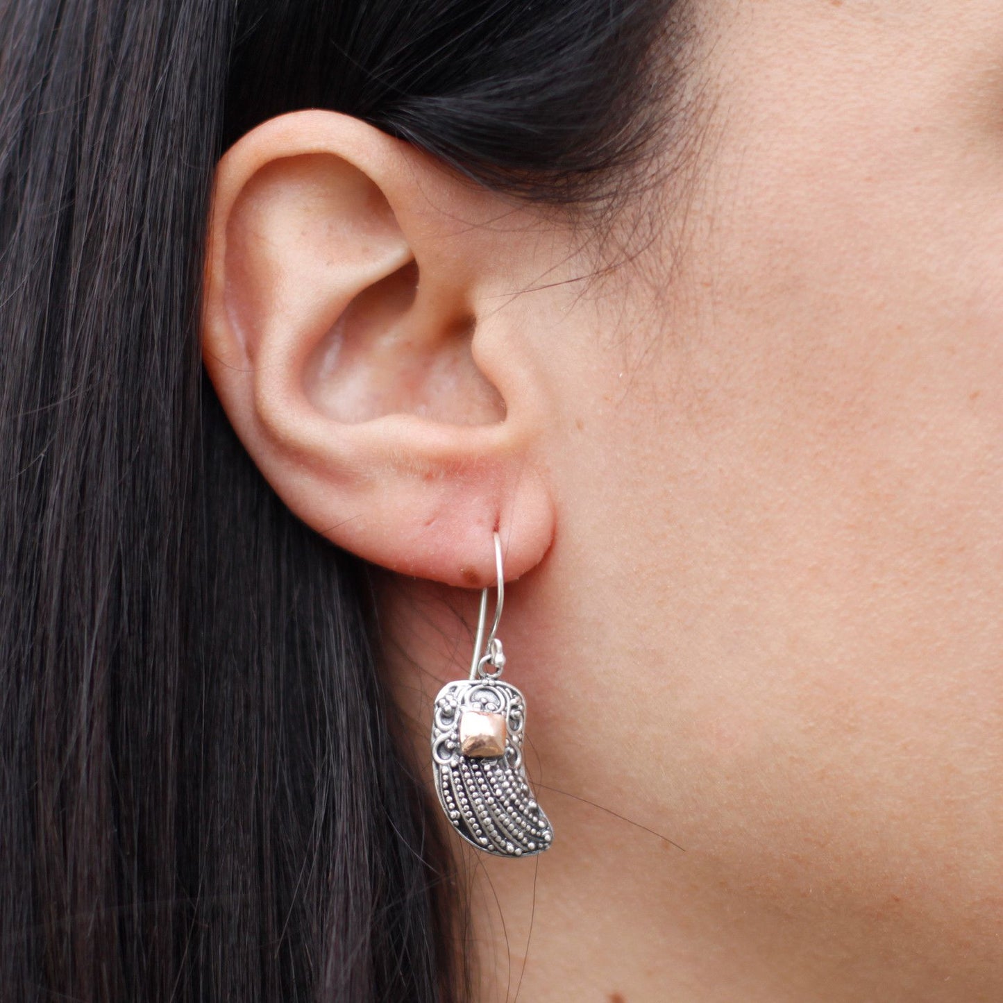 Delicate mixed metal angel wing earrings featuring contrasting silver and gold finishes in an elegant drop style.