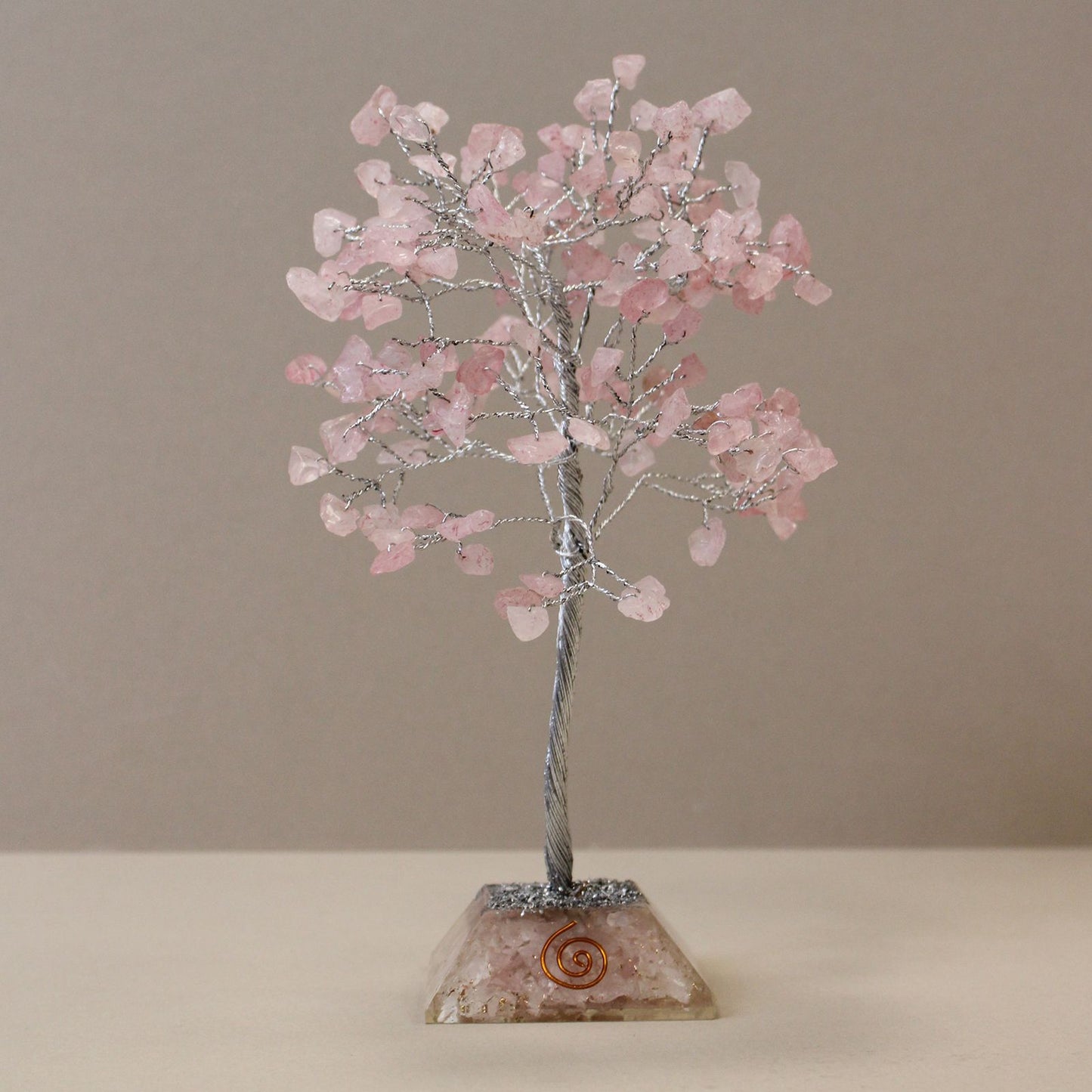 Delicate rose quartz gemstone tree with copper wire branches and a geometric resin orgonite base.