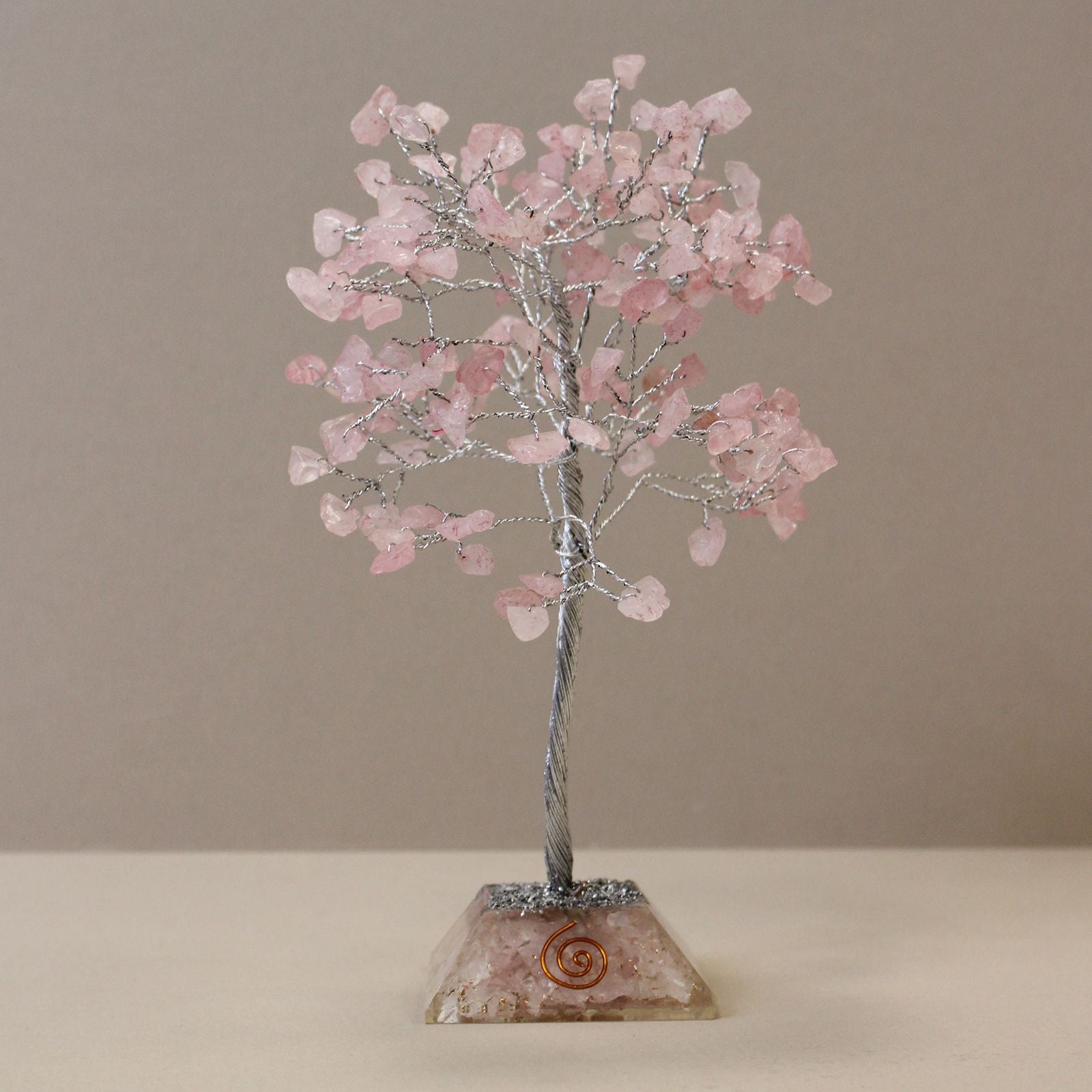 Delicate rose quartz gemstone tree with copper wire branches and a geometric resin orgonite base.