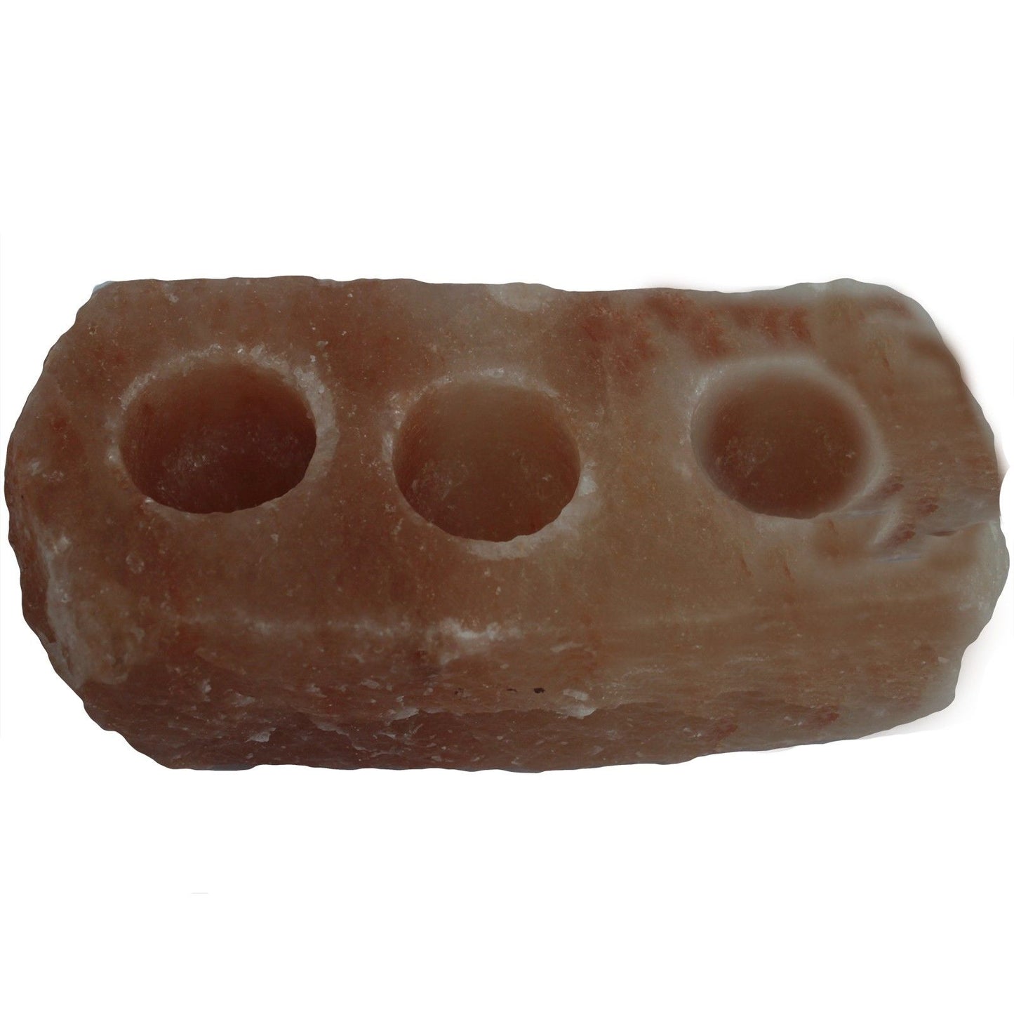Large natural pink Himalayan salt rock candle holder with three carved holes for tea lights on a wooden surface.