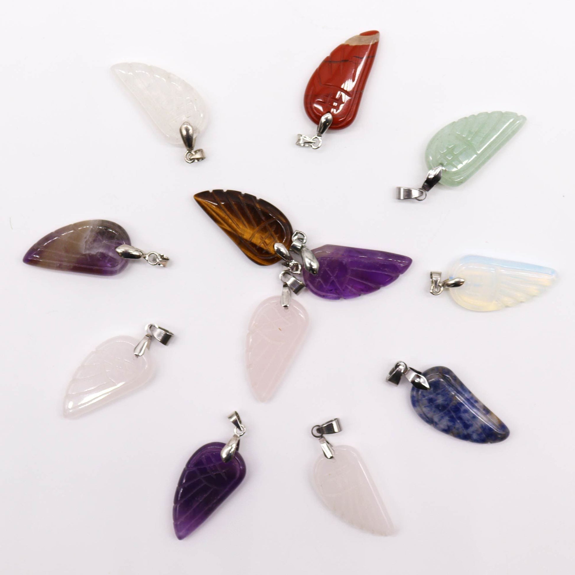 Twelve assorted colourful gemstone pendants carved into the shape of detailed angel wings.