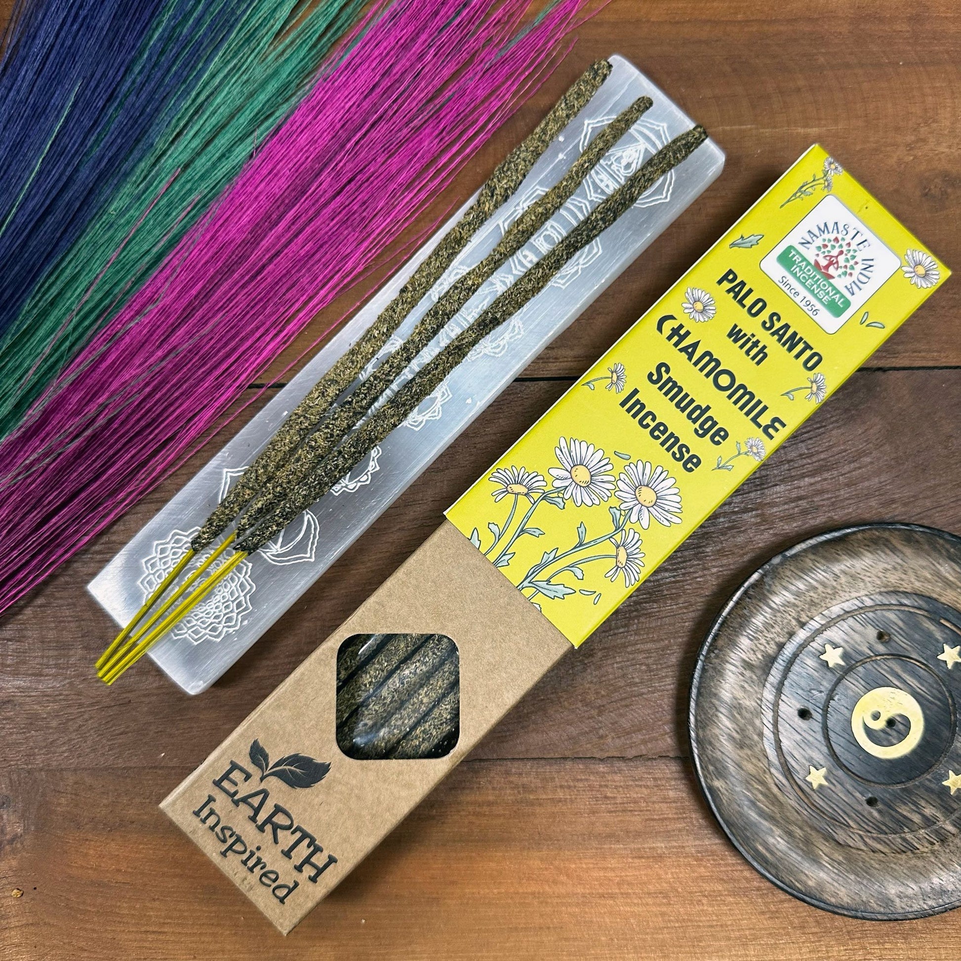 Handcrafted smudge incense sticks infused with chamomile and natural herbs on a neutral background.