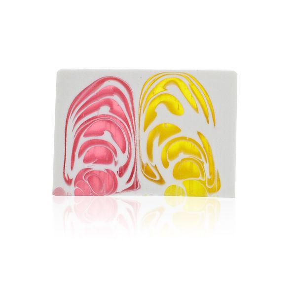 Close up of a handcrafted purple soap slice with delicate white patterns resembling an orchid flower.