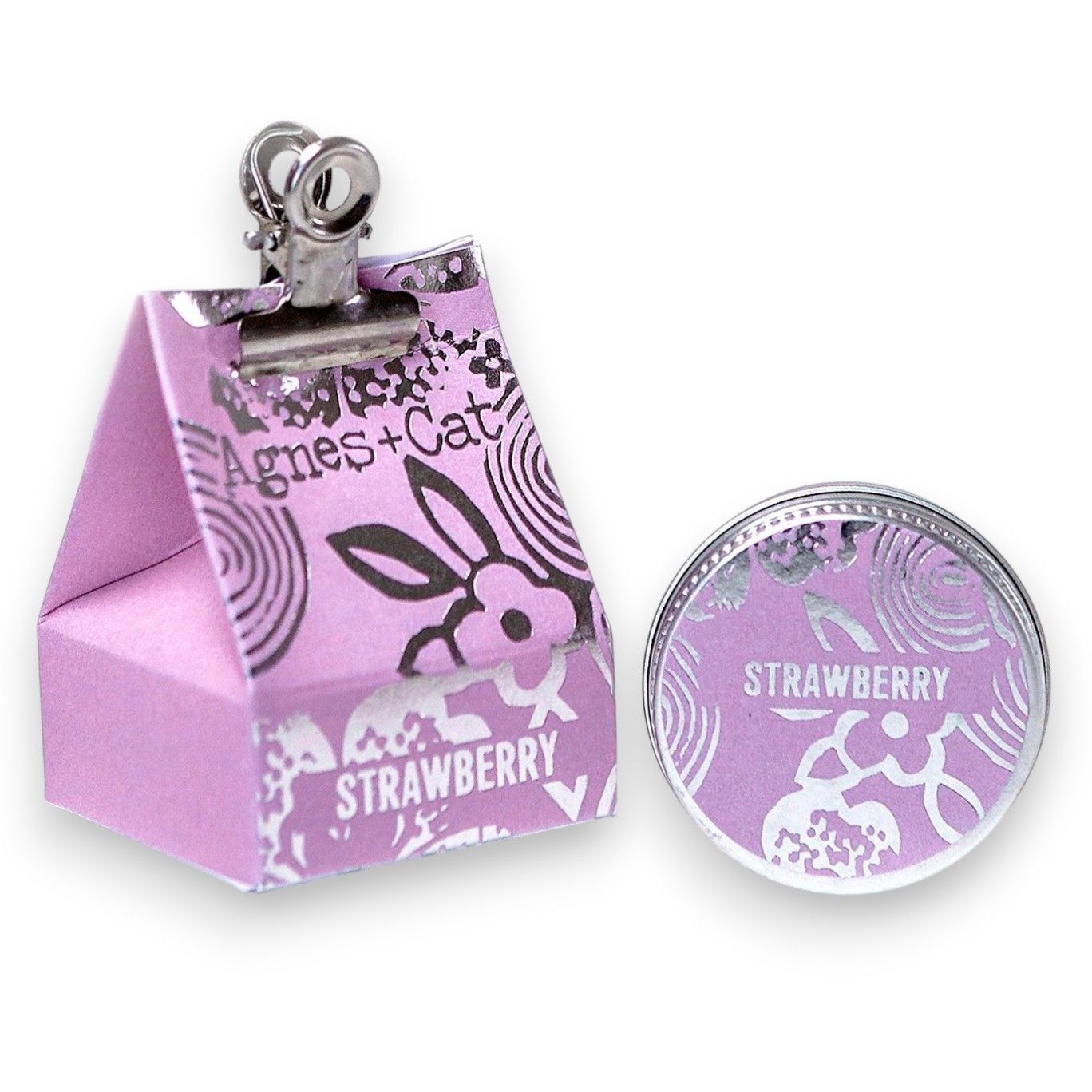 Small round tin of strawberry lip balm with a vibrant red label and sweet fruity fragrance.